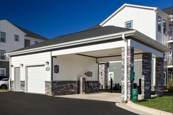 A white garage door is open revealing a garage.